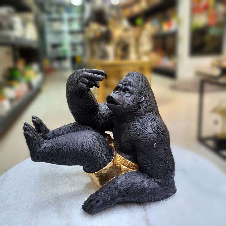 Gorila sentado con short dorado