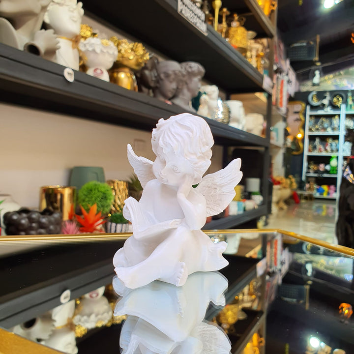 Ángel sentado Leyendo