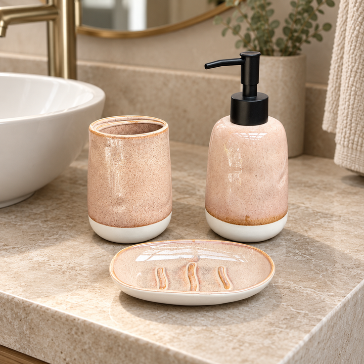 Dispensador, vaso y jabonera beige rosado moteado con base blanca, juntos sobre lavamanos