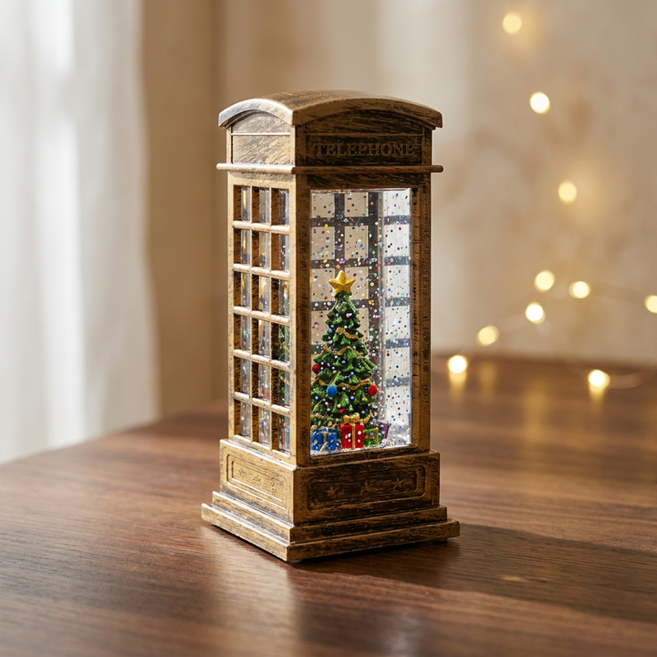 Cabina telefónica navideña dorada con escarcha y árbol de Navidad