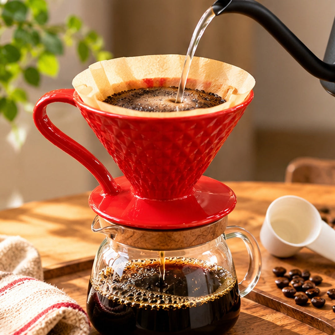 Dripper V60 rojo preparando café filtrado sobre jarra de vidrio