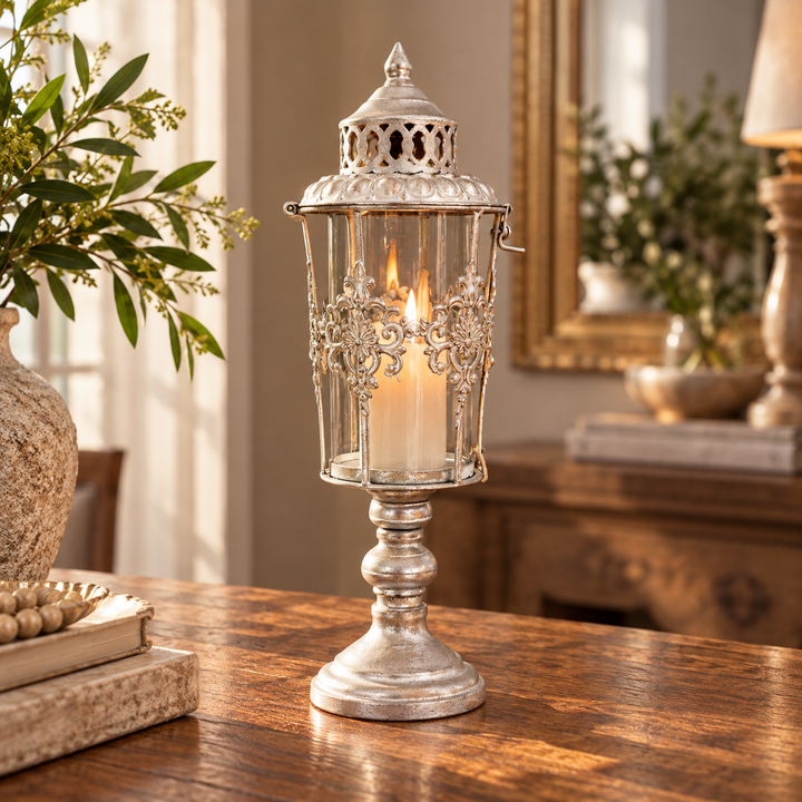 Candelabro farol plateado con filigranas y vela decorando un recibidor