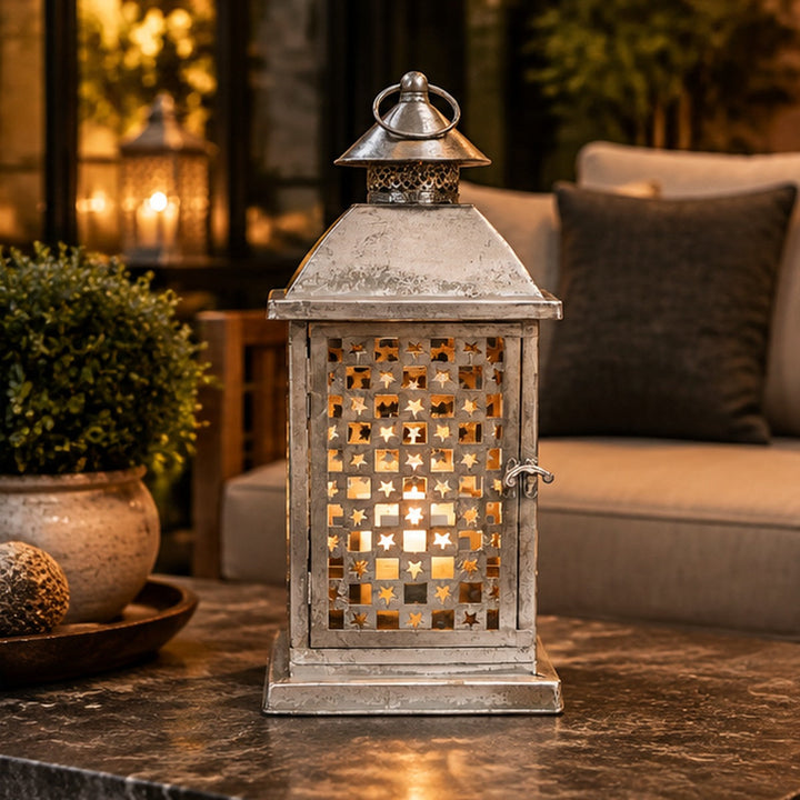 Fanal decorativo plateado con perforaciones de estrellas en living