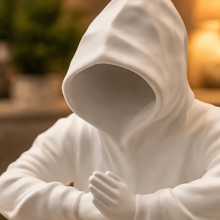 Detalle de capucha sin rostro y manos de escultura blanca