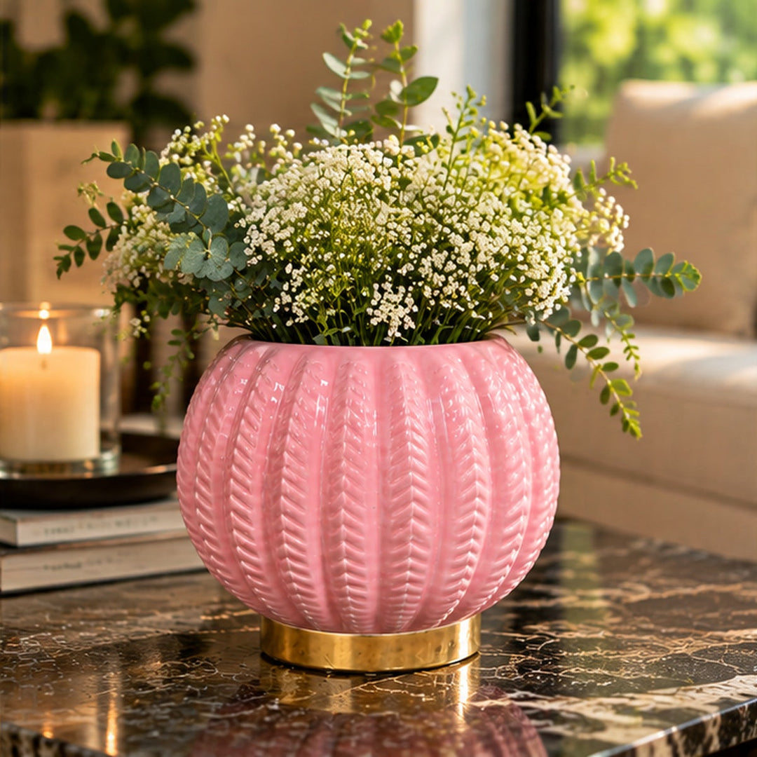Florero rosado con flores sobre mesa de mármol